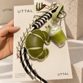UTTAL Matcha Croissant Bag Charm with green drink charm and decorative cord straps