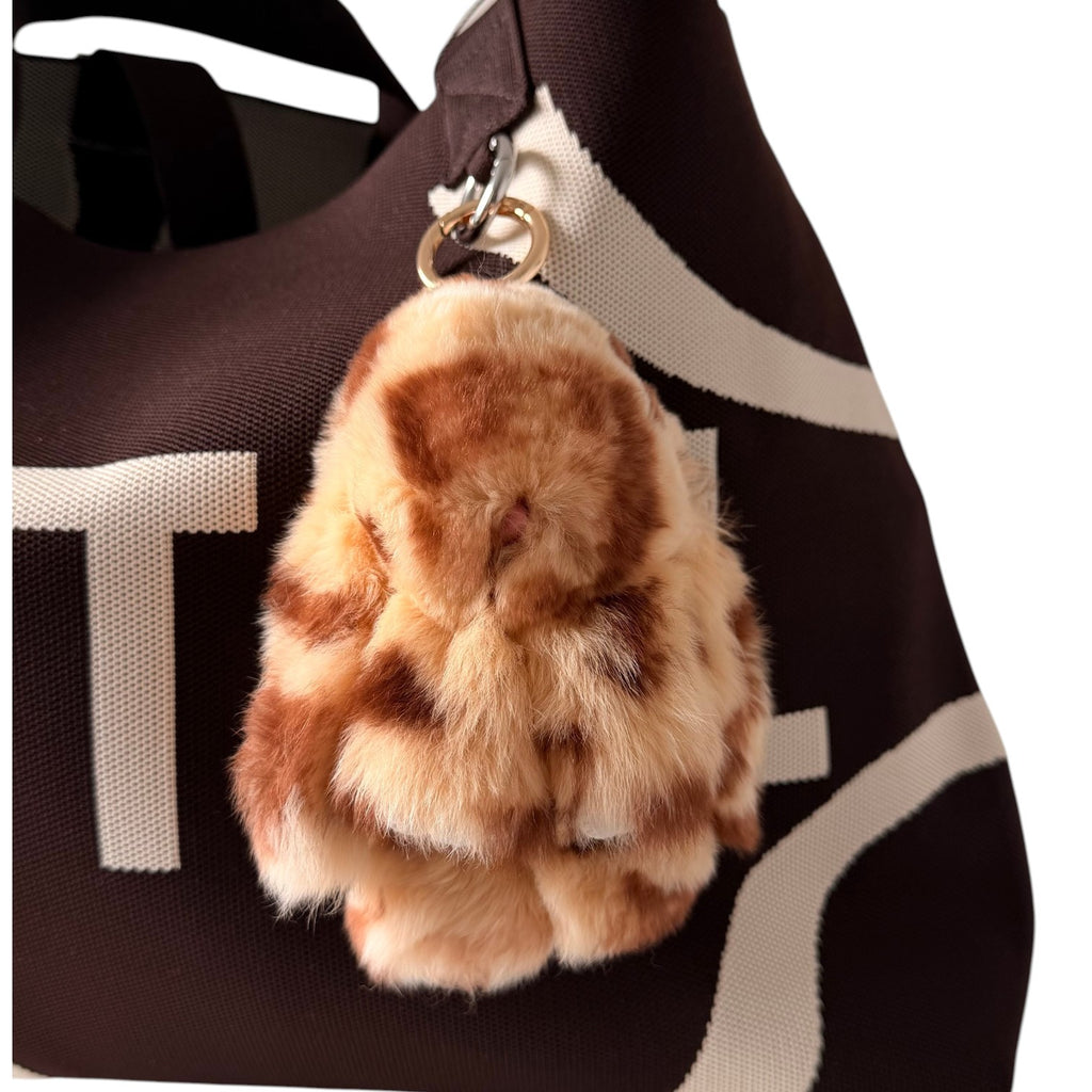UTTAL Toffee Plushy Bunny Bag Charm attached to a brown knitted tote bag